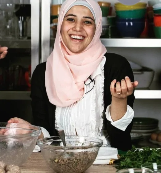 Chef Salsabil Matouk sorrindo enquanto prepara kibe na cozinha