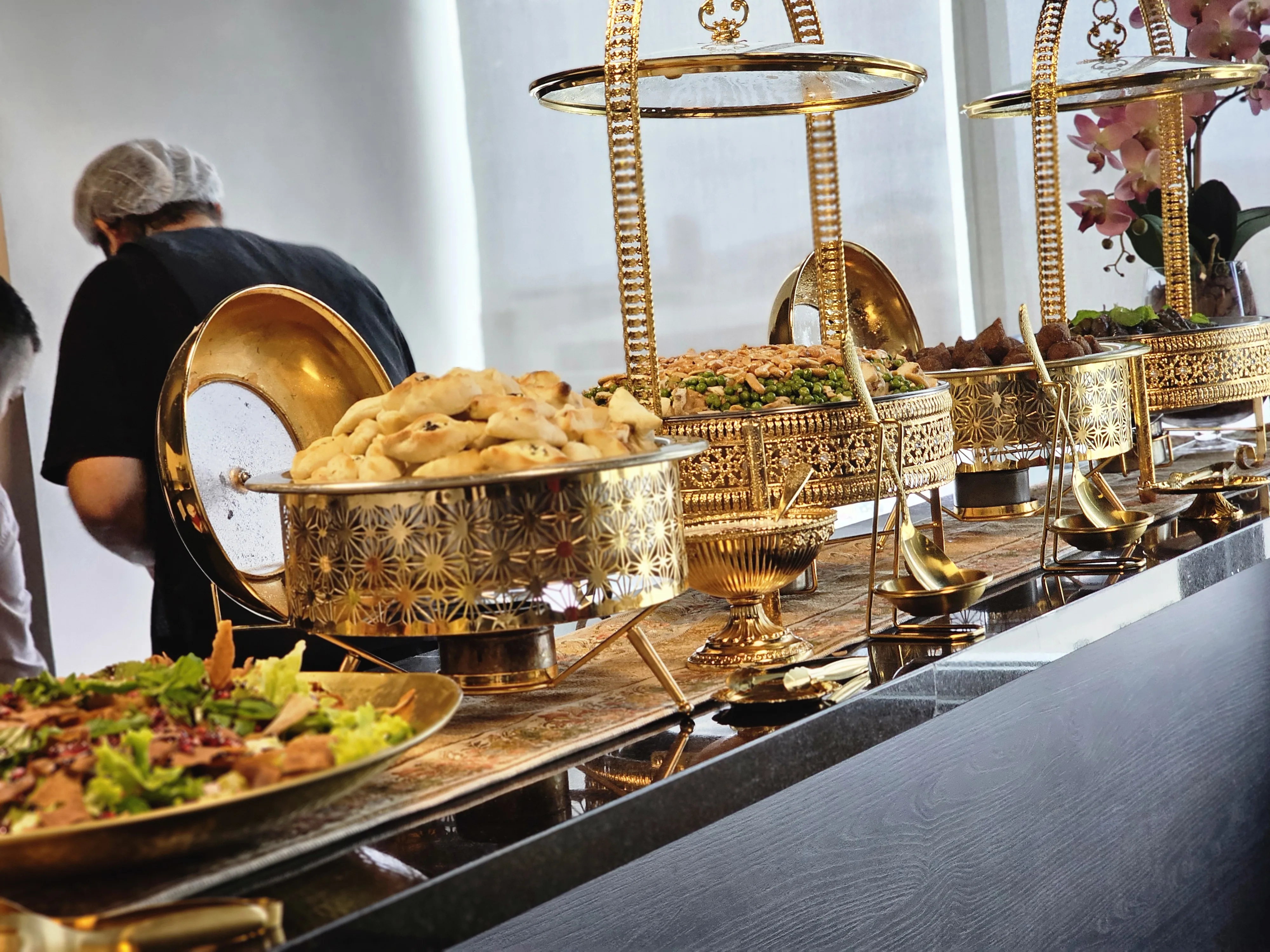 Buffet árabe dourado em evento corporativo