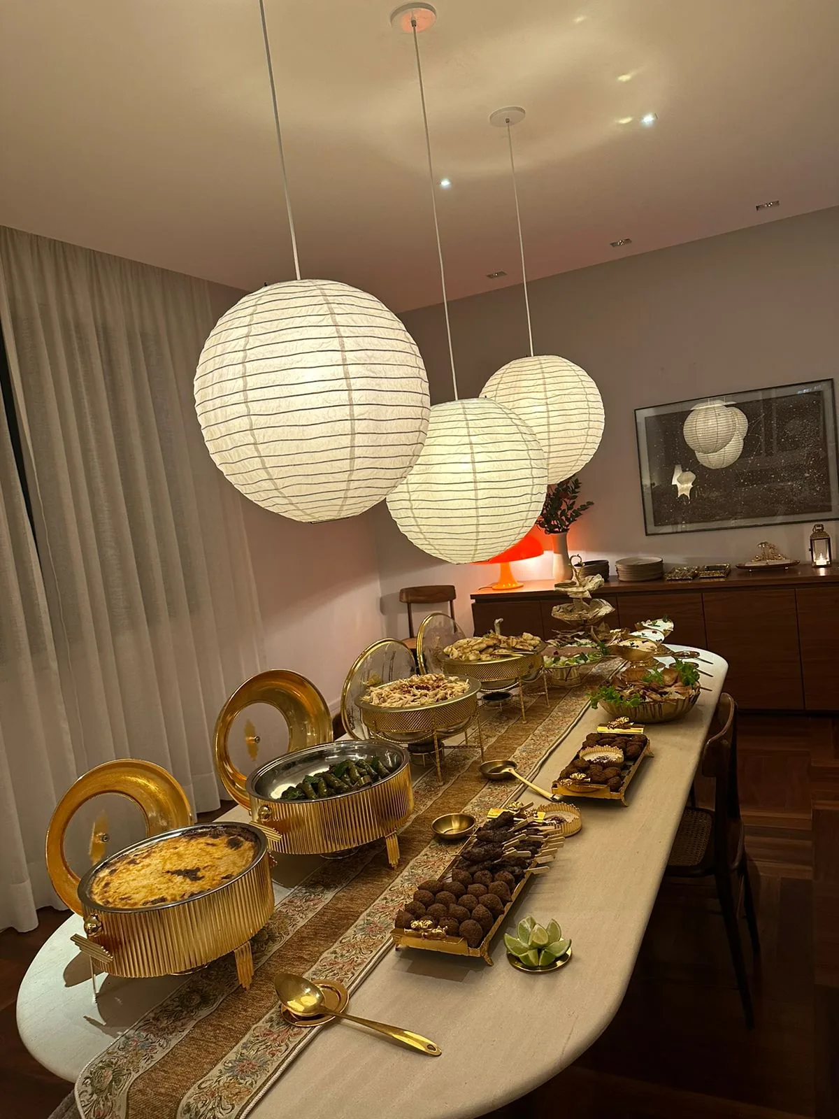 Mesa árabe noturna com luminárias douradas em jantar temático