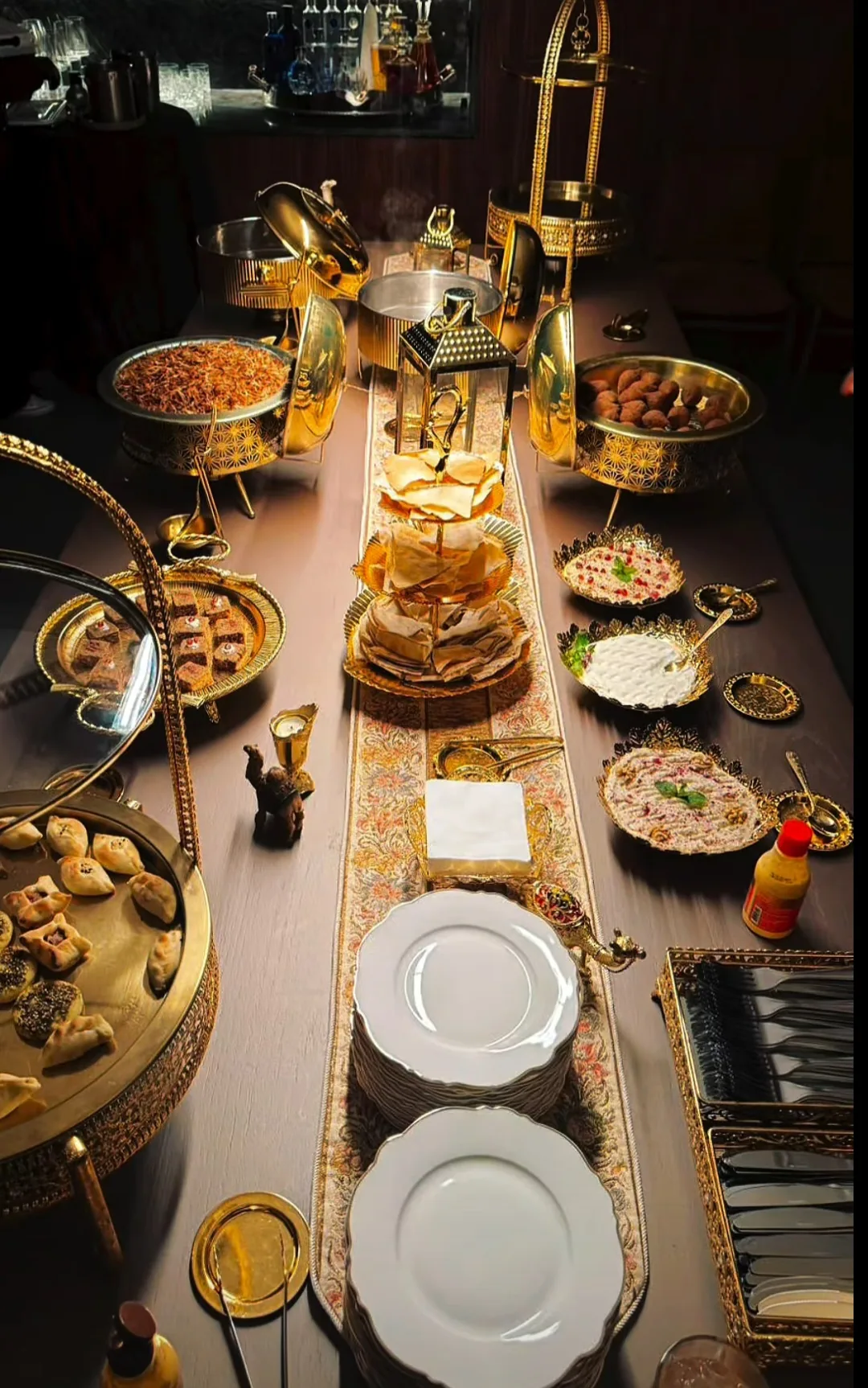 Mesa árabe elegante com rechauds e decoração oriental dourada